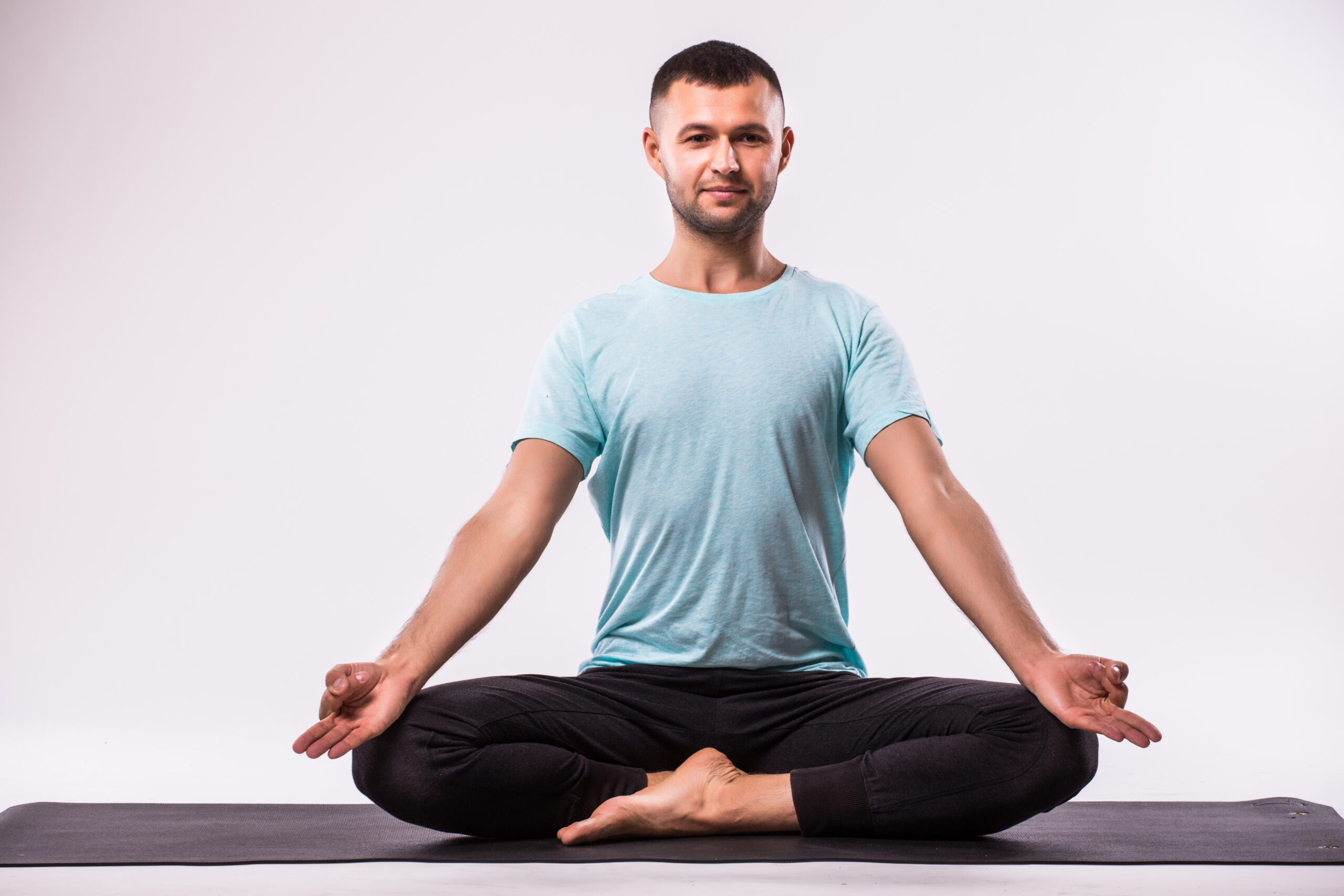 Handsome man doing yoga exercise isolated on a white background